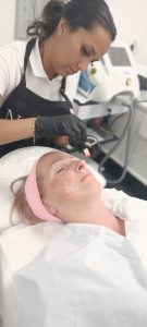 beautician giving client geneo+ facial